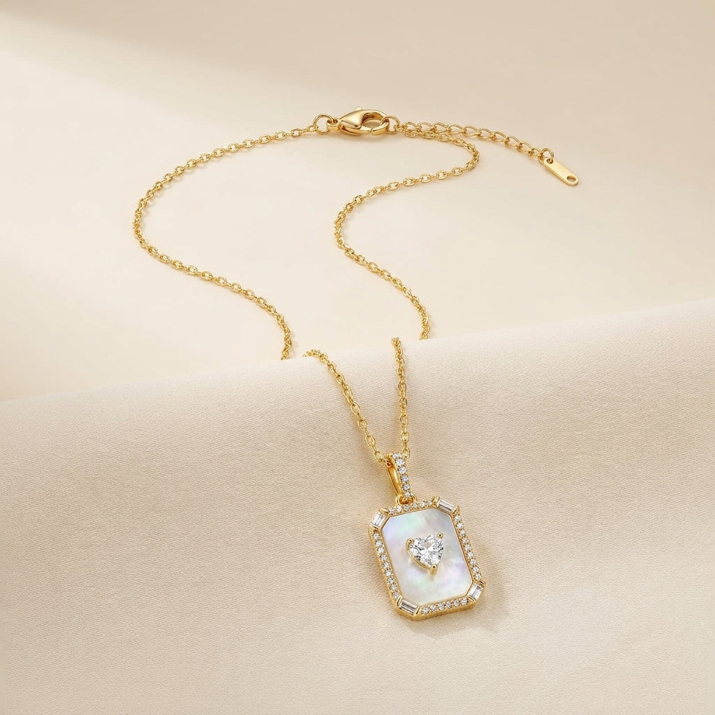 Rectangular mother-of-pearl pendant necklace with heart-cut CZ centre stone and baguette pavé halo on an 18K gold-plated adjustable chain
